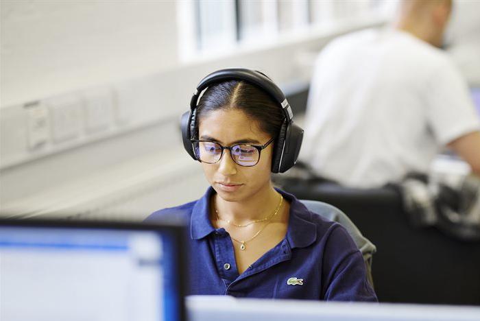 A student wears headphones and uses a St Marys computer.