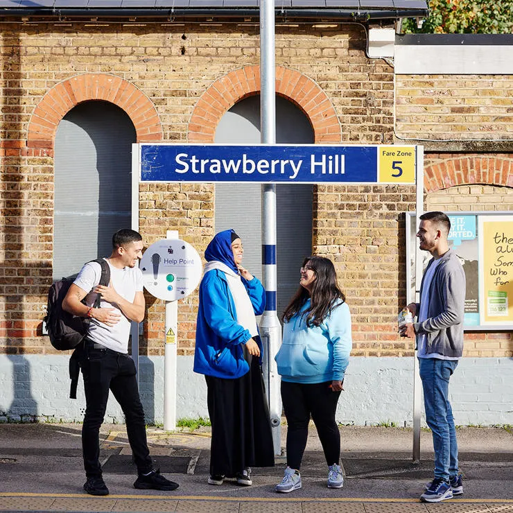 Students stood talking on a platform at Strawberry Hill Train Station.
