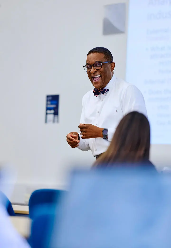 Kofi business lecturer teaching and laughing