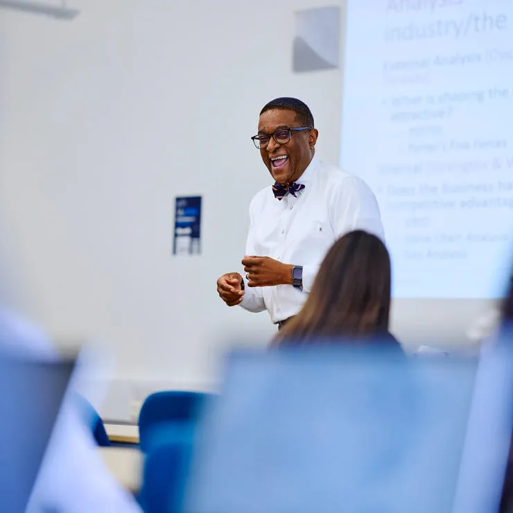 Kofi business lecturer teaching and laughing
