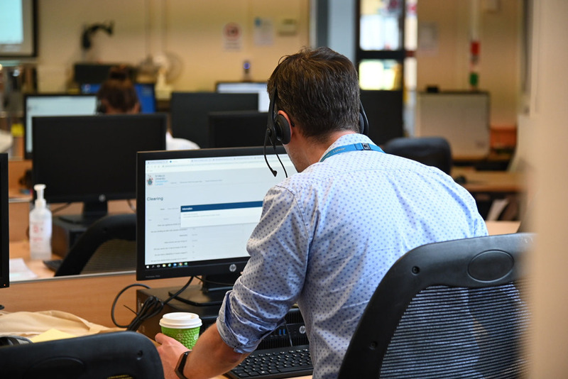 Person sitting at a desk working on a computer in an office environment.