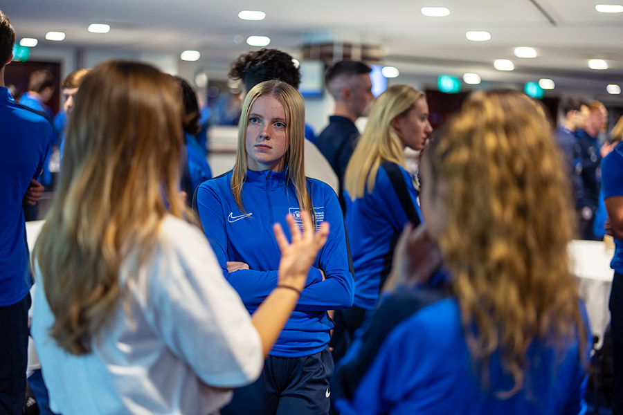 Students on the Chelsea Football Coaching degree stand discussing their learning.