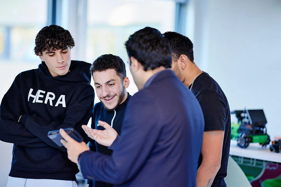 A computer science tutor shows students a mobile device during a cyber security course at St Mary's University, London.