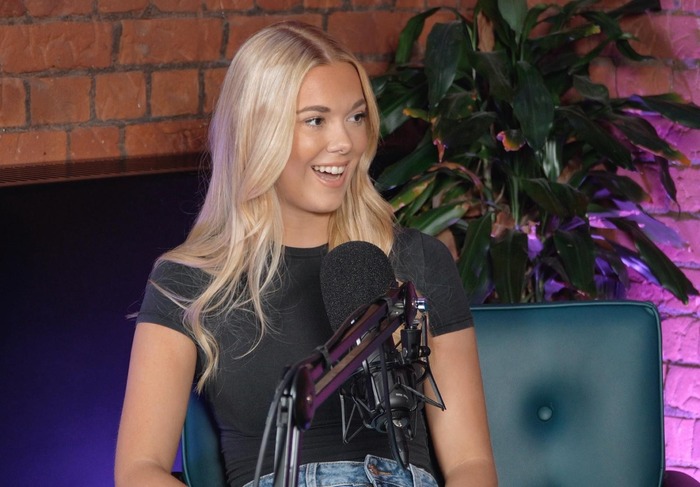 A female multimedia journalism student holds an interview in a podcast studio.