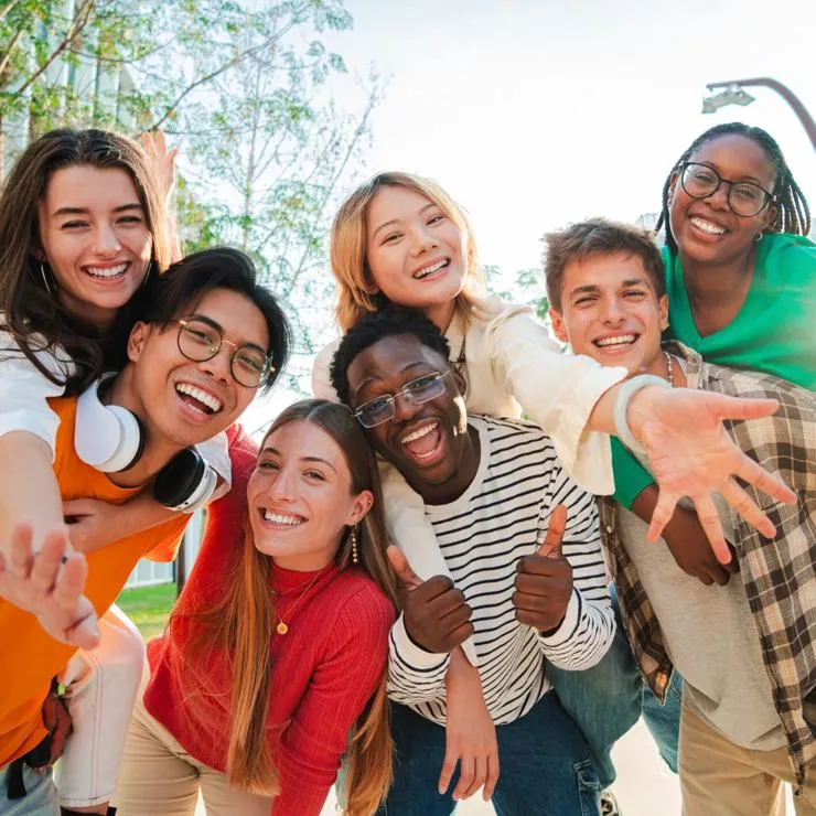 A group of seven smiling students posing together outdoors.