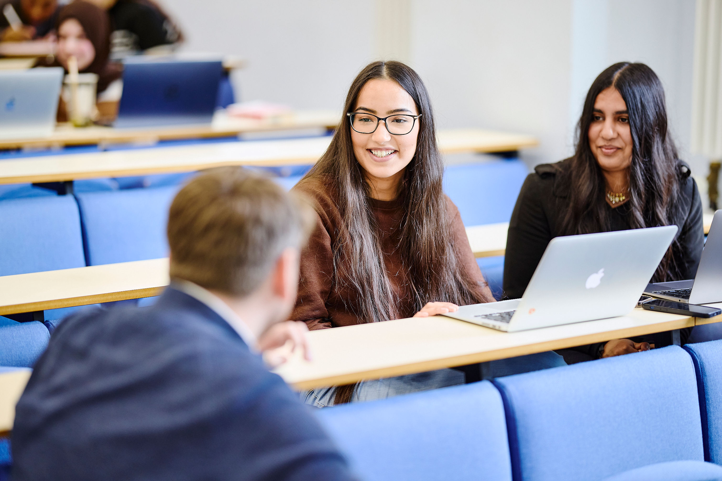 group of students smiling around laptop