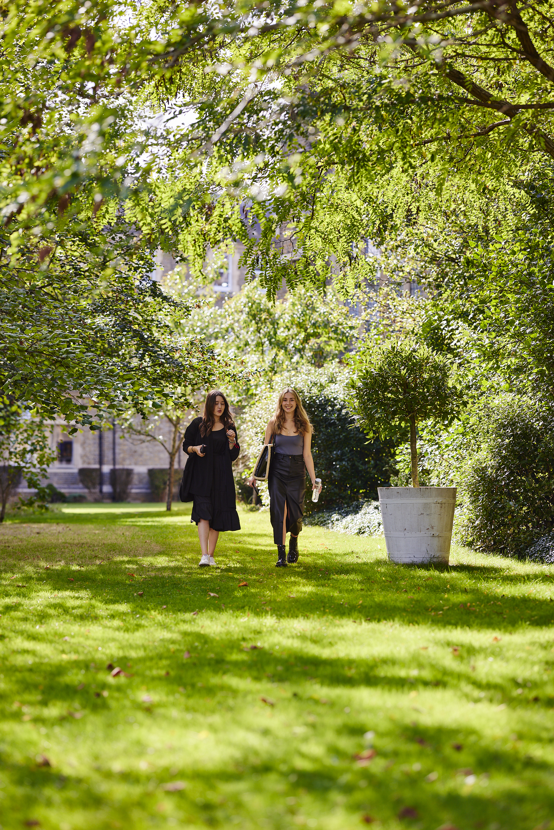 2 students walking in St Mary's green campus grounds