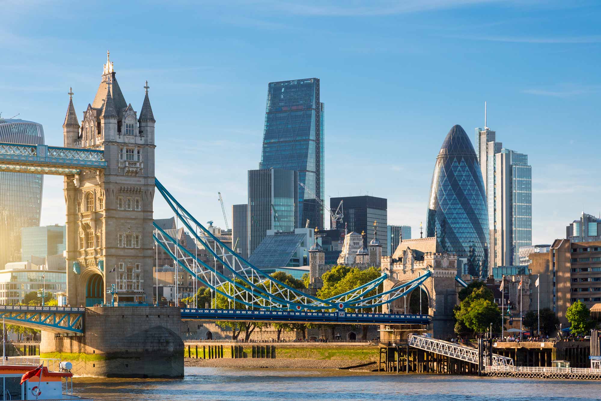 A skyline view of London's financial district, showing Tower Bridge and various other landmarks.