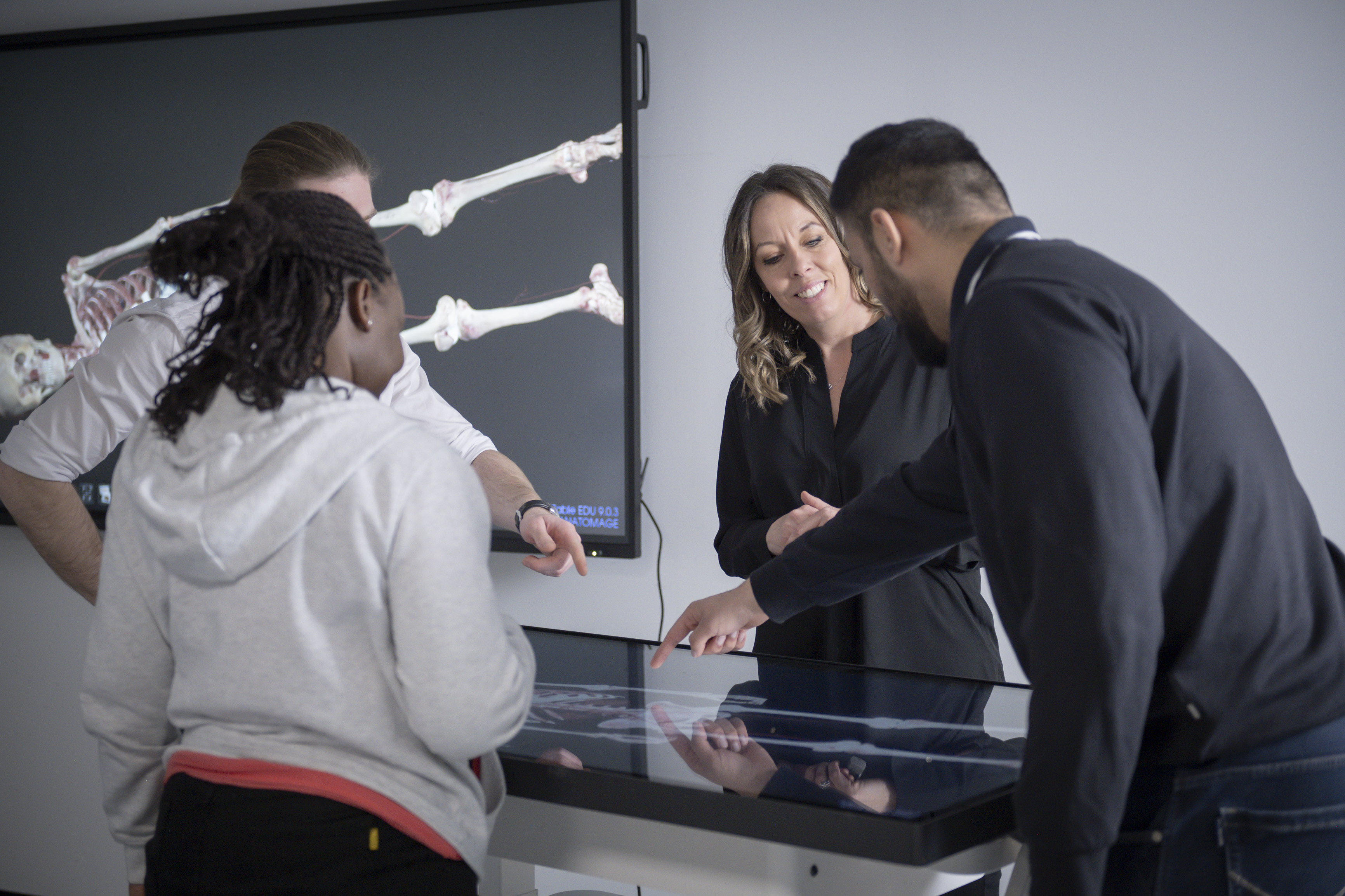 School of Medicine students studying bones with digital display