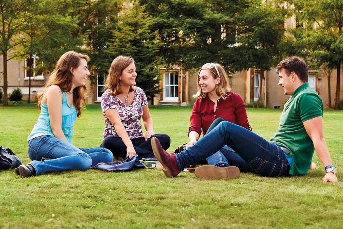 Students sitting and chatting on the grass
