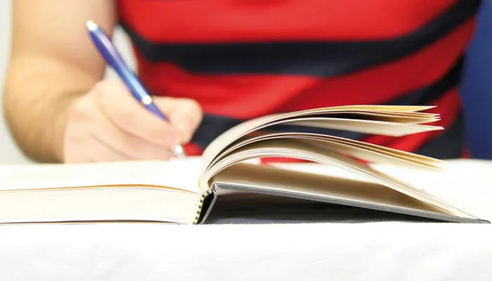 Person writing in a book
