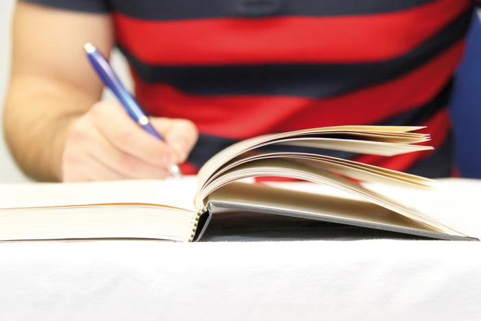 Person writing in a book