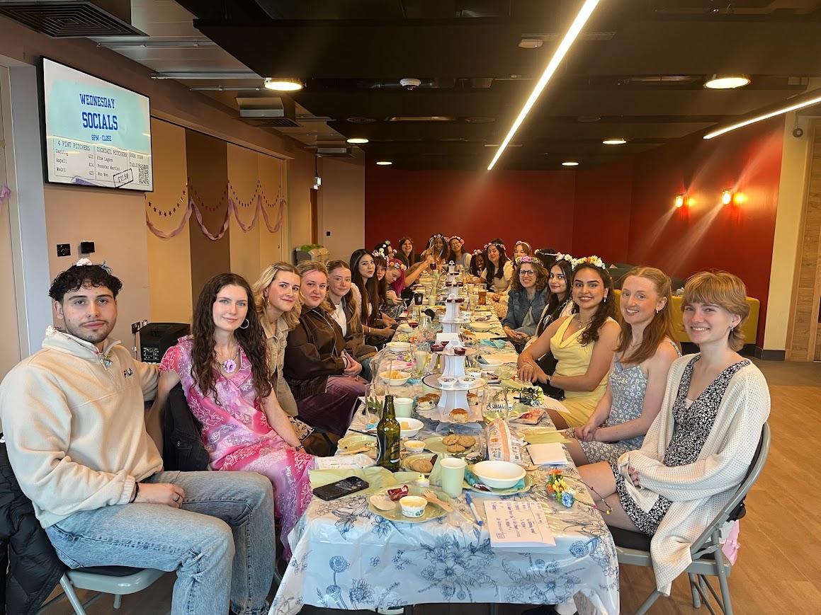 Students gathered at a decorated table during a St Mary's University social event.