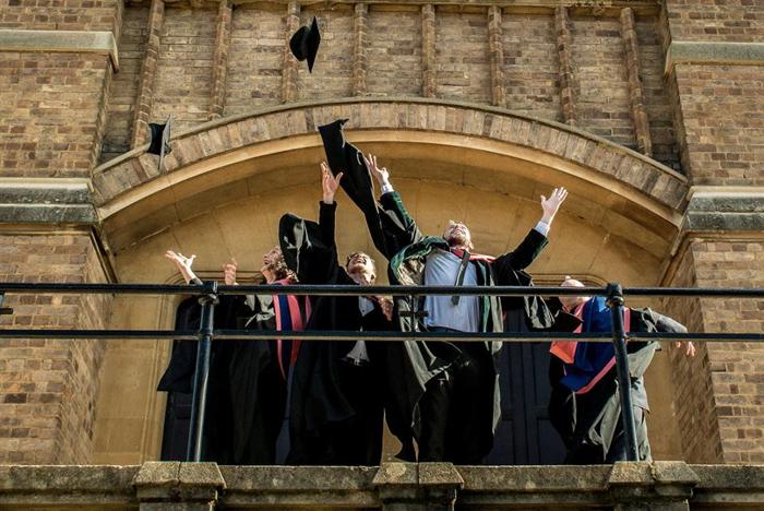 Graduating students throw their caps into the air outside our chapel.