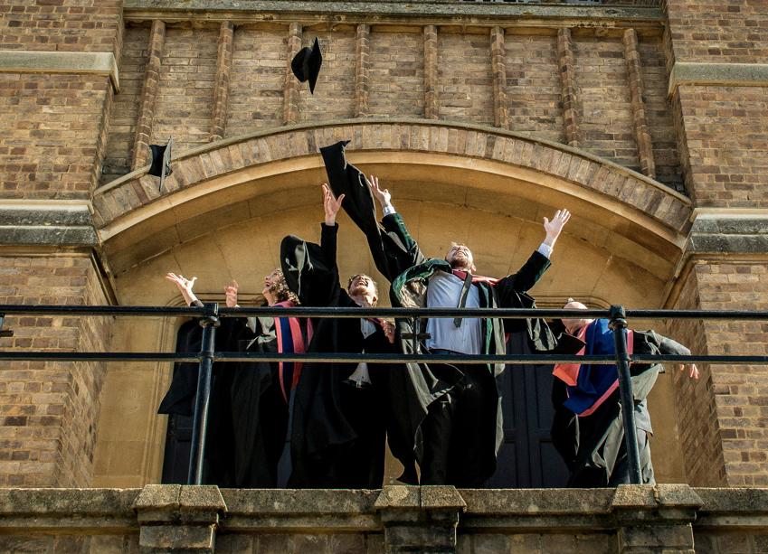 Graduating students throw their caps into the air outside our chapel.