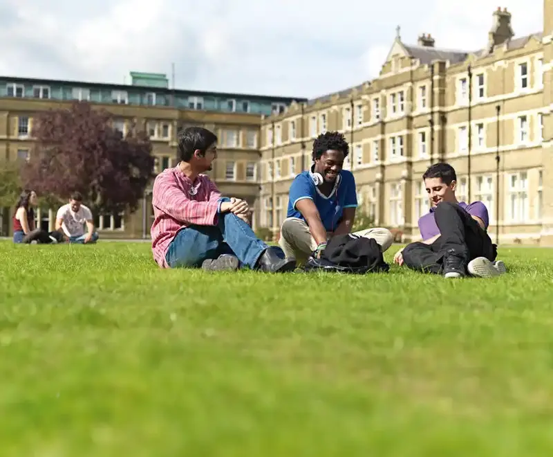 International students at St Mary's are relaxing and chatting on the green between classes.