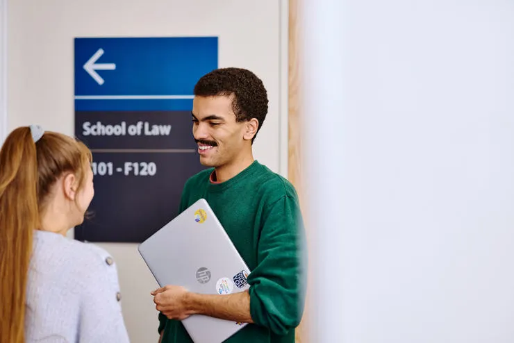 male student in front of school of law sign
