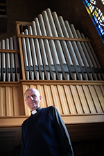 Fr Vlad Feltzmann stood beside current chapel organ