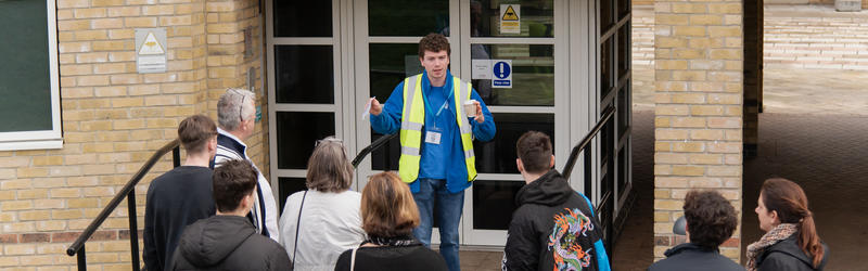 A student ambassador talking to students and parents on an accommodation tour.
