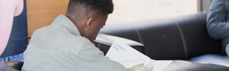 A student reading the campus map in the Dolce Vita cafe.