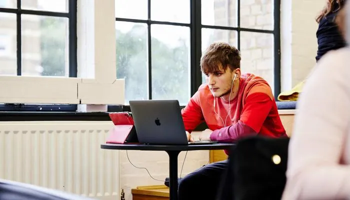 Student working on laptop in library