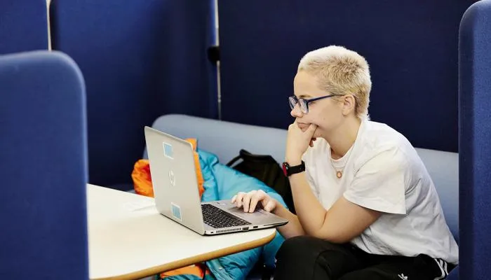 Student working on laptop in library