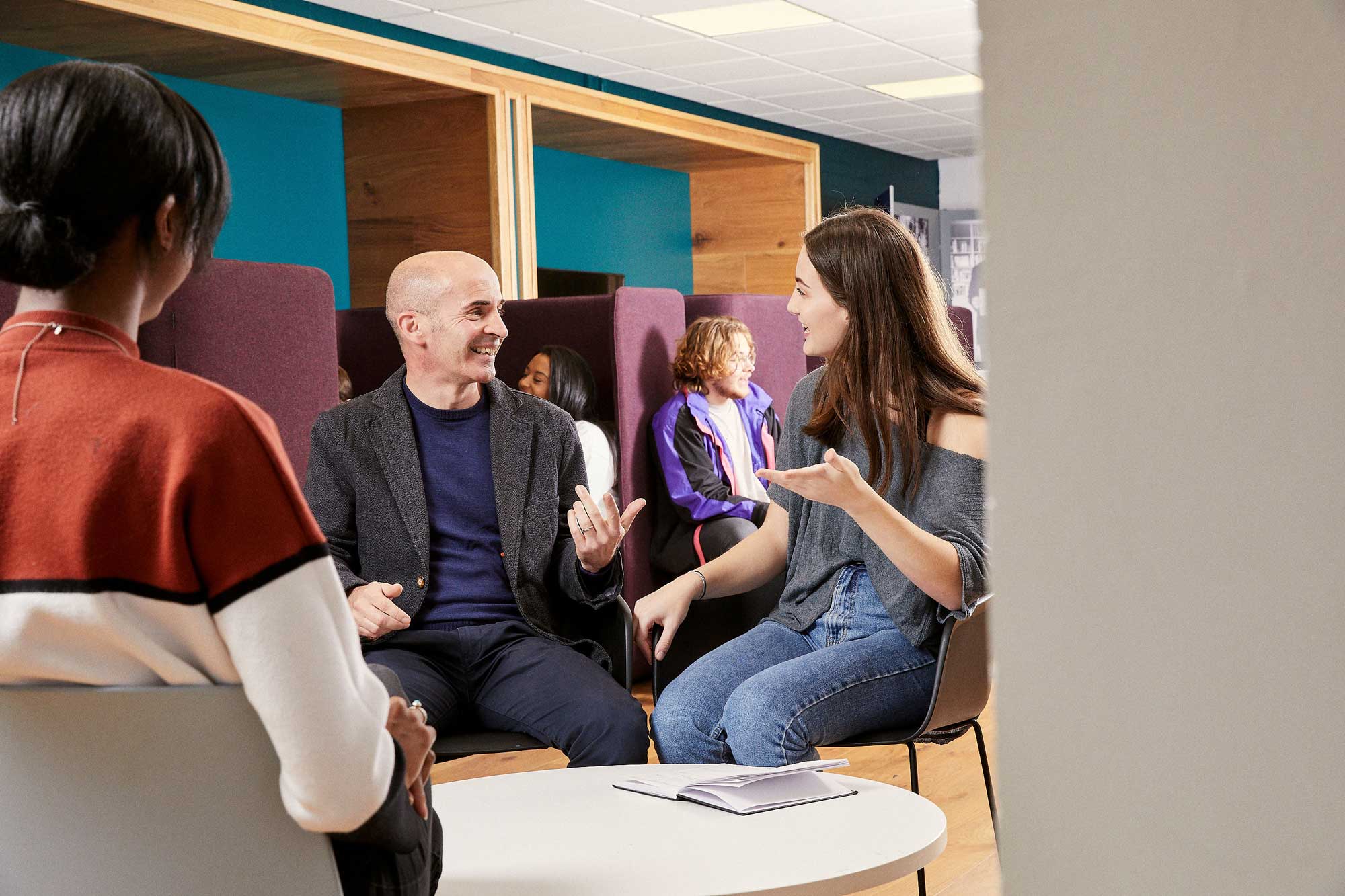 Students speaking to one another in the library.