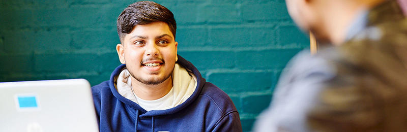 Student sat with a laptop