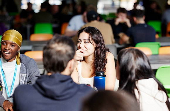 Students socialising in a busy university campus café.