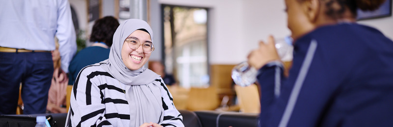 A student smiling with a friend in the Dolce Vita Café