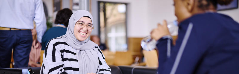 A student sat and smiling in the Dolce Vita Cafe.