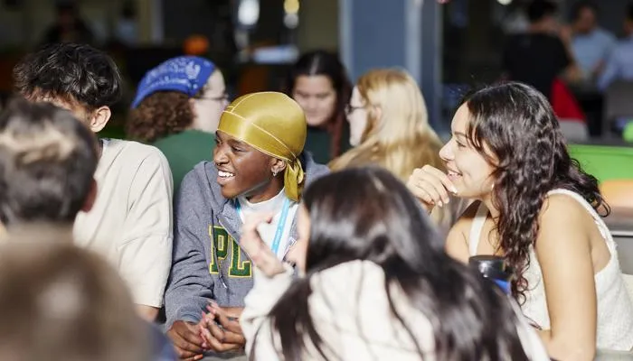 Students laugh and chat.