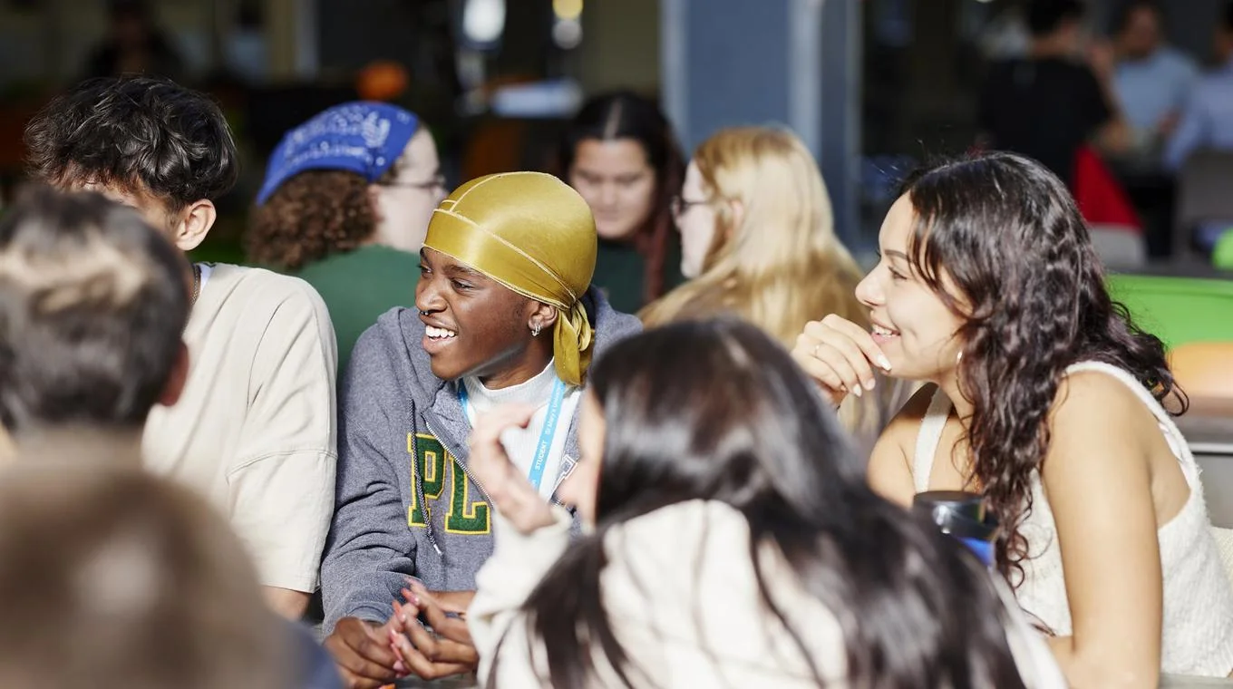 Students laughing and chatting, making the most of university life at St Mary's.
