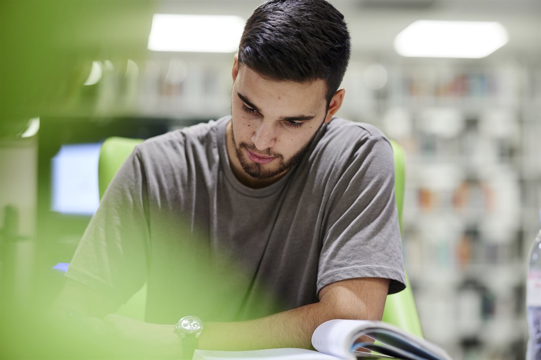 A student reads a book while studying for an exam.