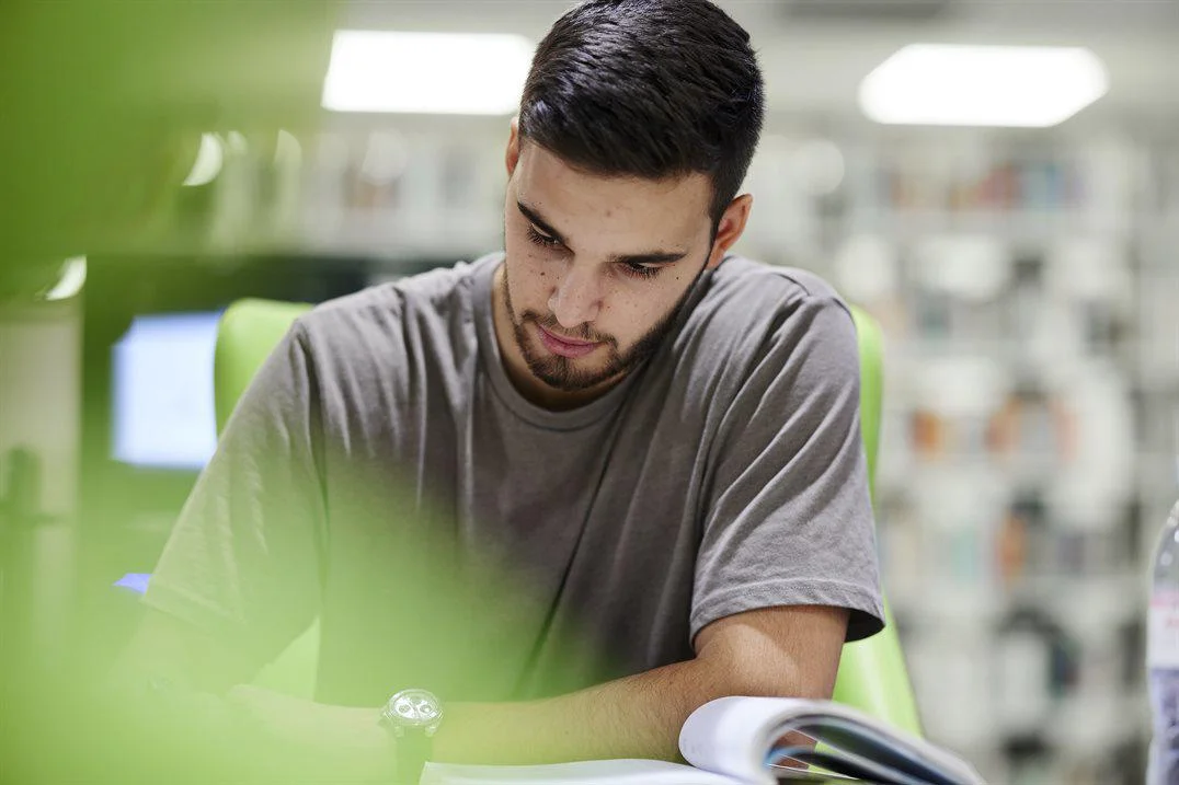 A student reads a book while studying for an exam.