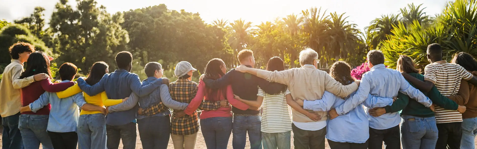 Students watch the sunset with their arms around one another.