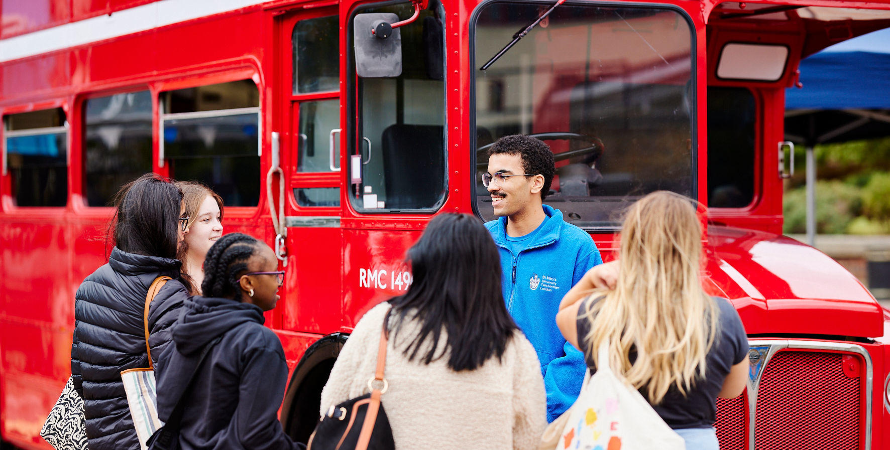 students talking in front of london bus welcome week