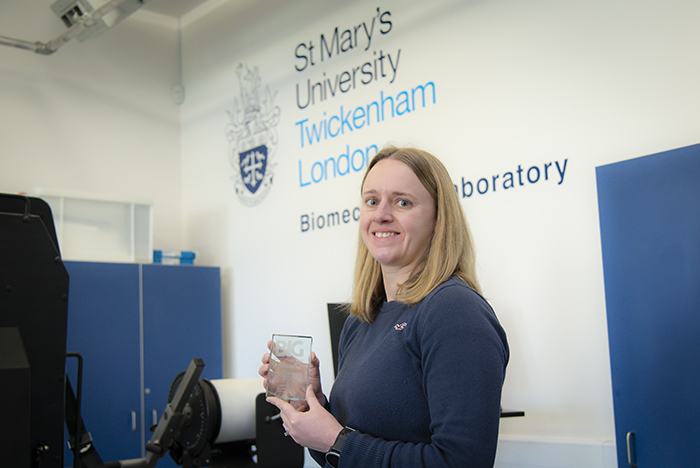 Alex Atack in front of St Mary's logo on white wall