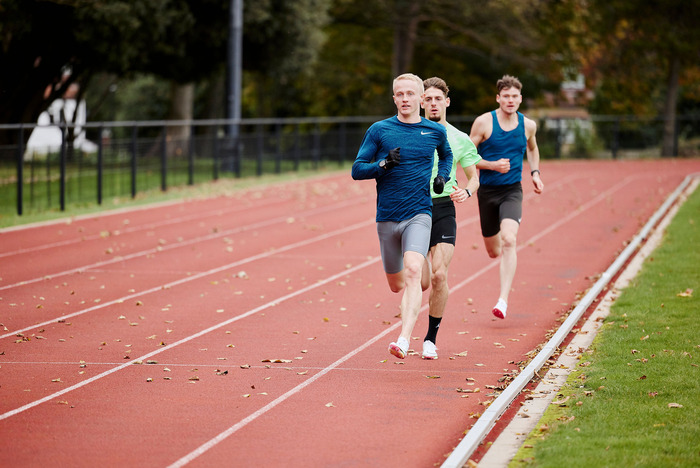 Three students running on the running track.