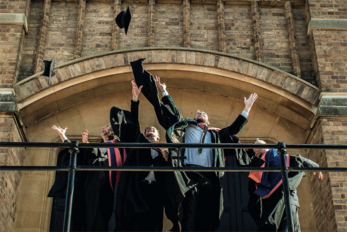 students celebrating graduation outside chapel