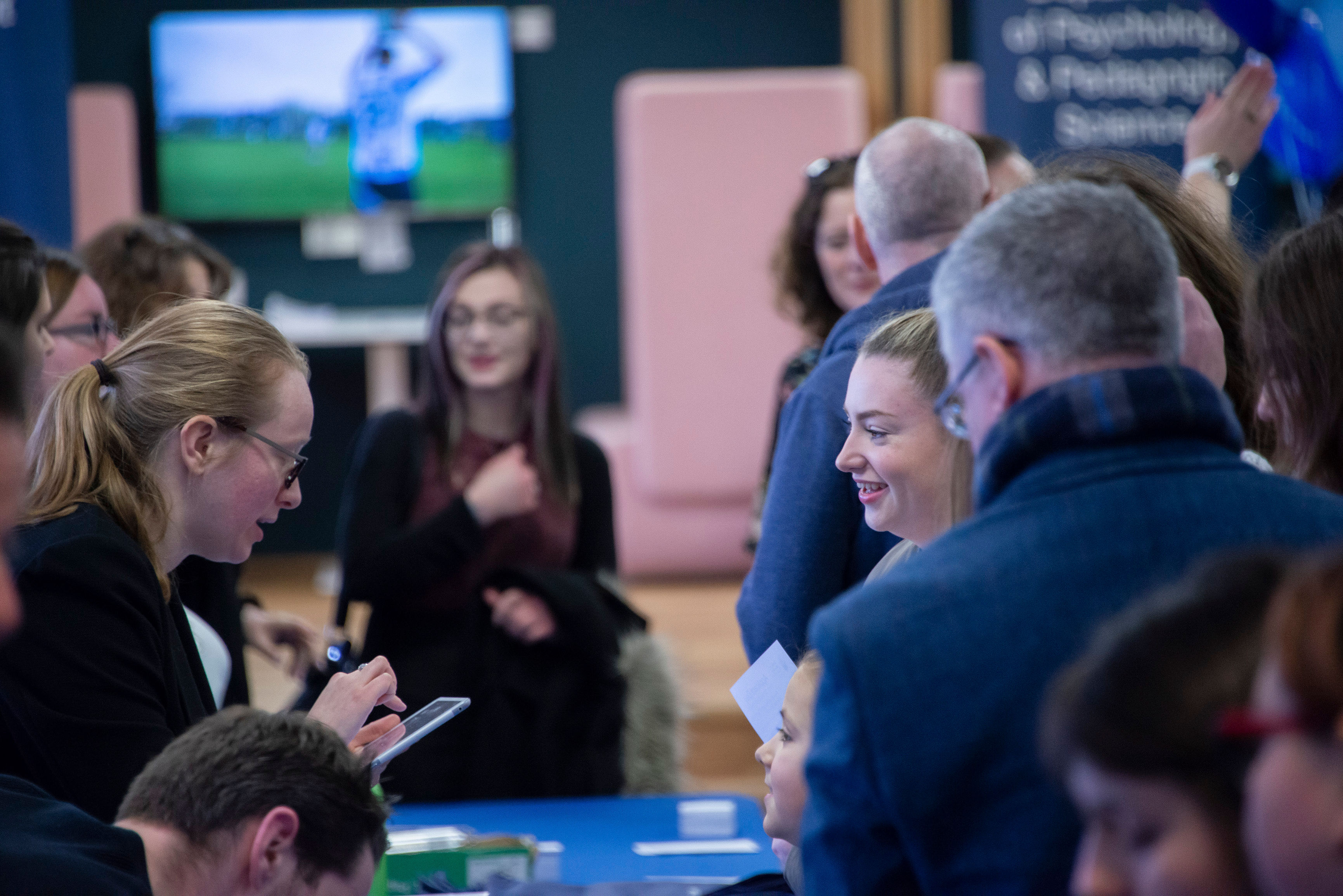 A visitor smiling at the registration desk at St Mary's University's Open Day