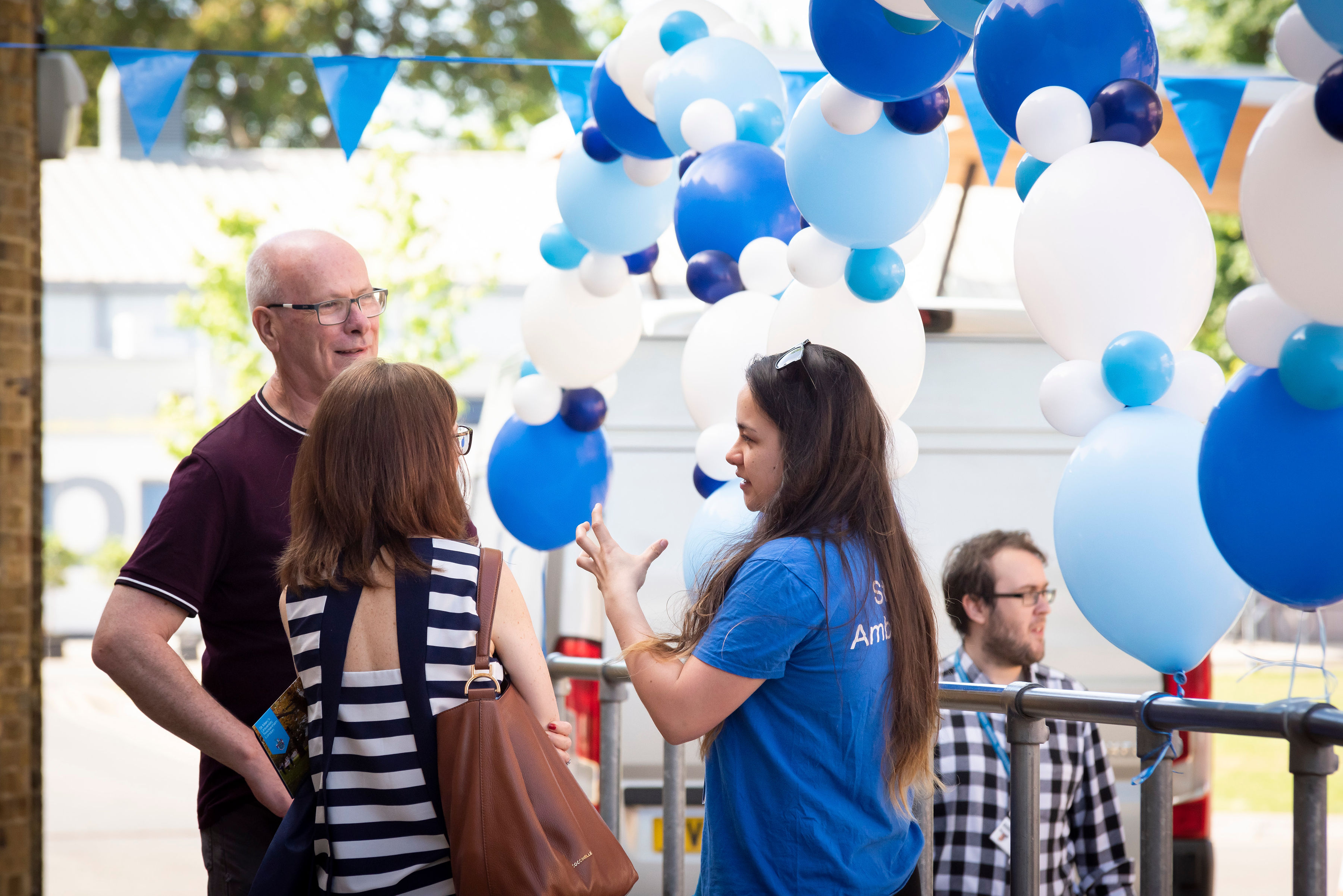 Open Day visitors talking to an ambassador next to decorations at St Mary's University